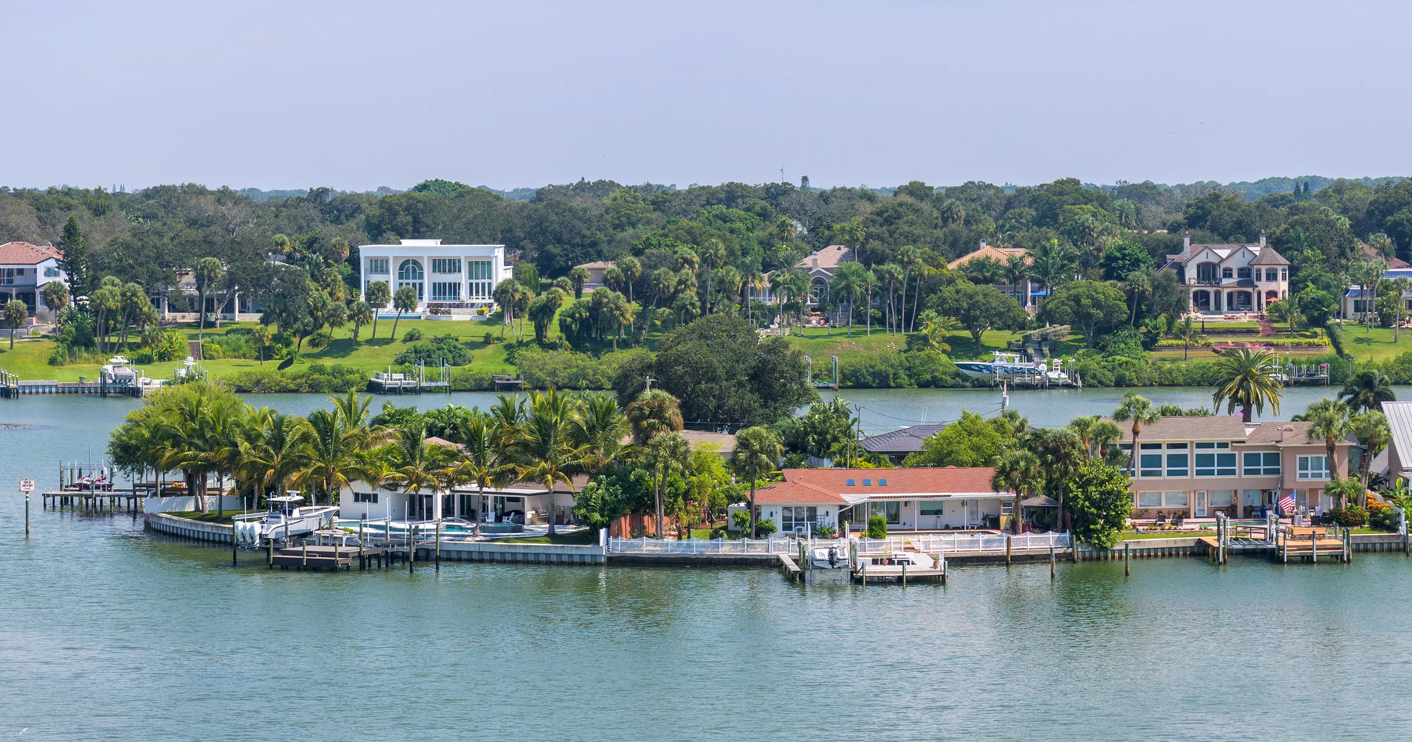 Waterfront homes with private docks along a Pinellas County channel on a clear day