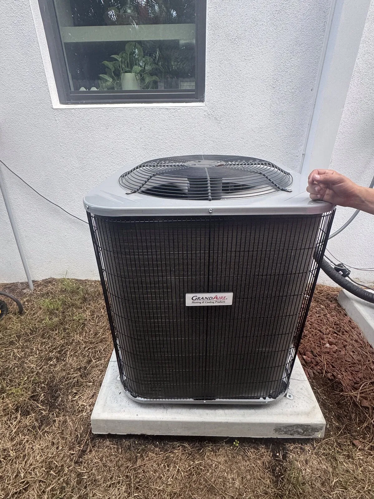 Outdoor AC unit beside landscaping and irrigation in a back yard, St. Petersburg FL