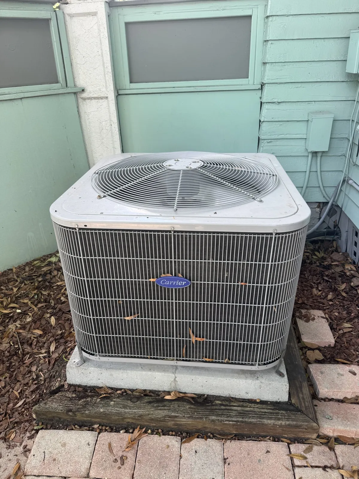 Carrier outdoor AC unit on a concrete pad beside a house off Howard Ave in Hyde Park, Tampa FL 33606