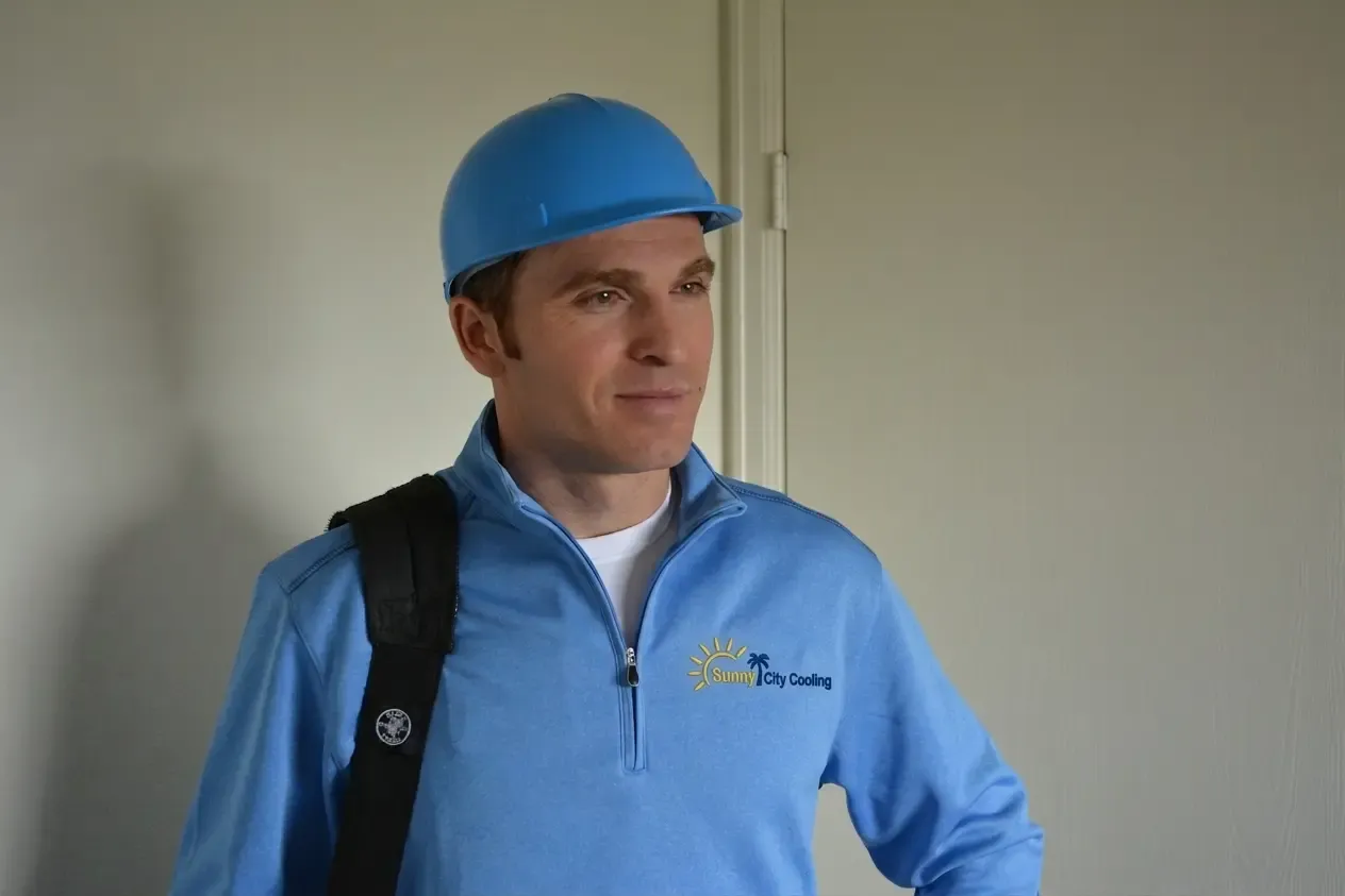 Sunny City Cooling technician in branded gear, tool bag over the shoulder